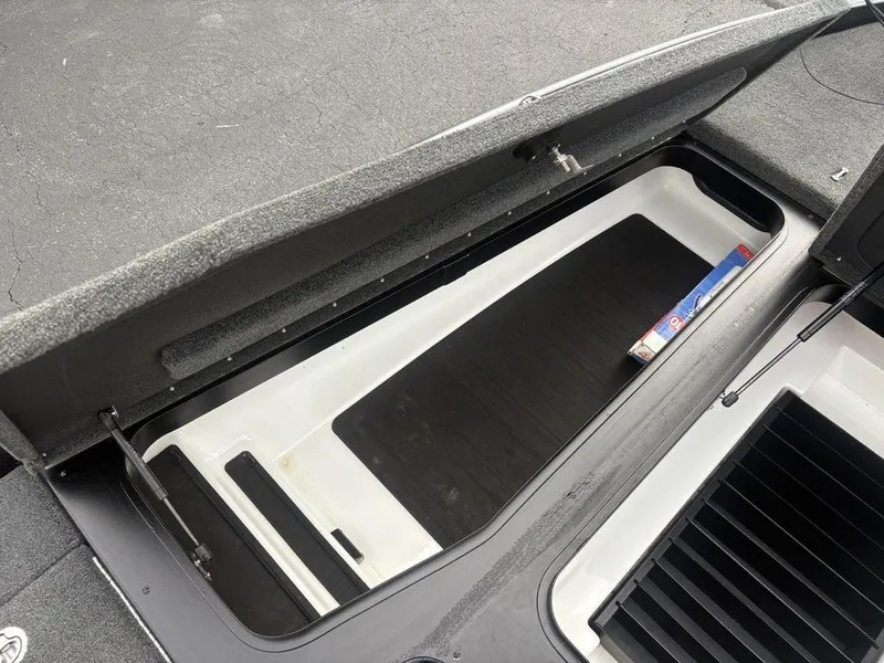 Slide: The Image of Open storage compartment in 2023 Skeeter ZXR 20 boat, featuring spacious interior and carpeted lid. - 8