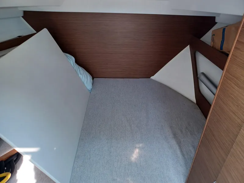 Slide: The Image of 2022 Jeanneau NC Weekender 795 Series 2 cabin interior with bed and wood paneling. - 6