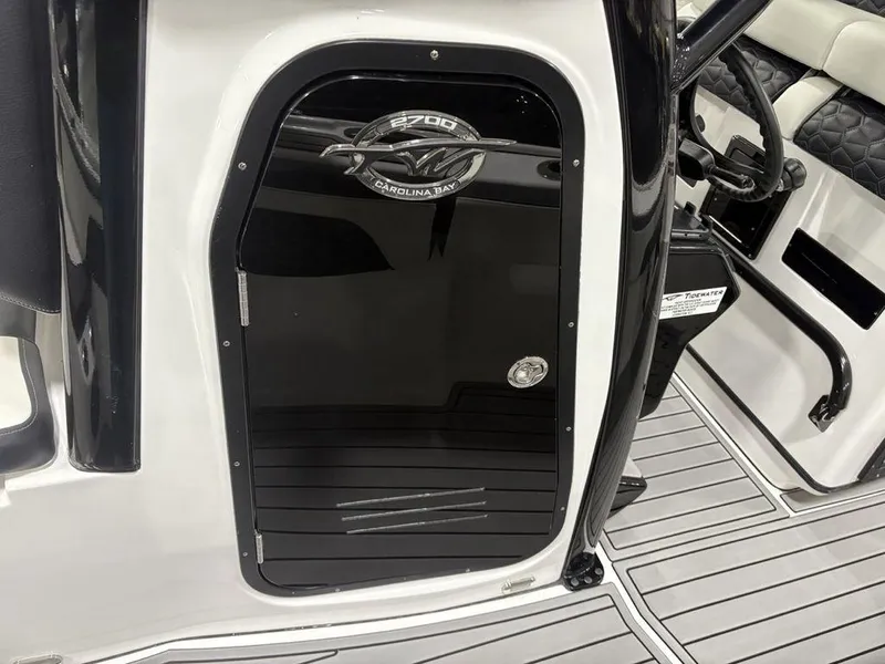Slide: The Image of 2026 Tidewater 2700 CB boat interior with sleek black door and modern steering wheel. - 19