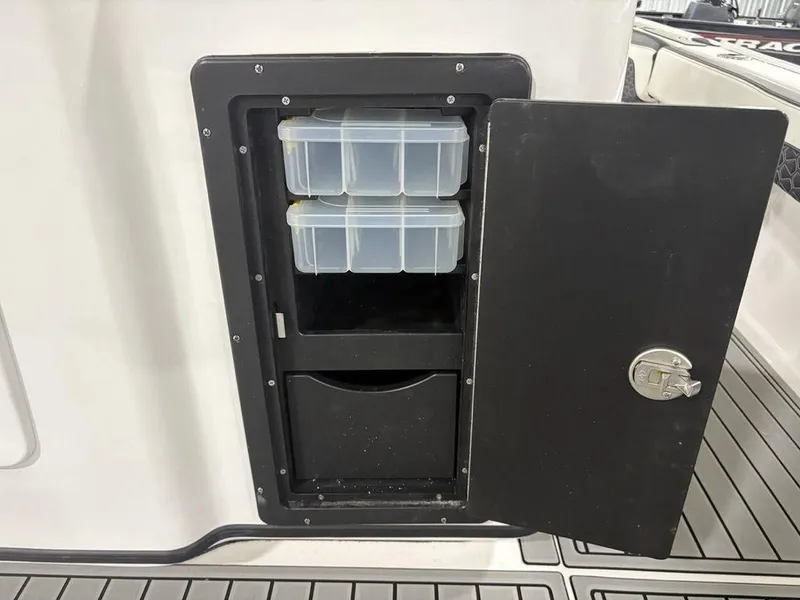 Slide: The Image of Storage compartment on 2026 Tidewater 2700 CB boat with organized plastic containers. - 33
