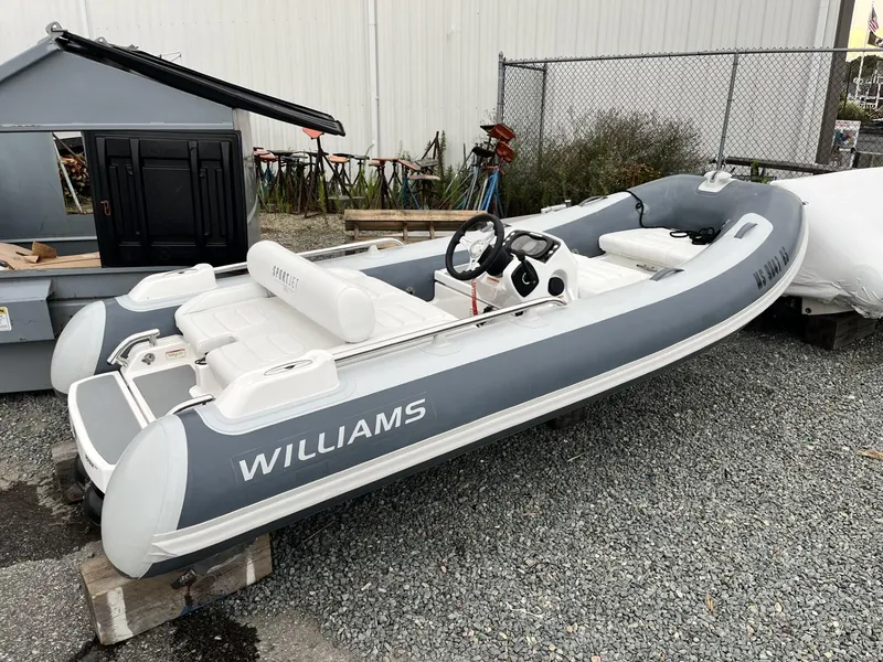 Slide: The Image of 2022 Williams Jet Tenders Sportjet 395 inflatable boat on gravel surface. - 2