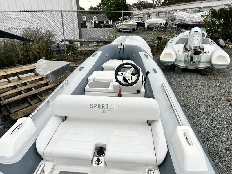 Slide: The Image of 2022 Williams Jet Tenders Sportjet 395, sleek design, parked on gravel lot. - 3