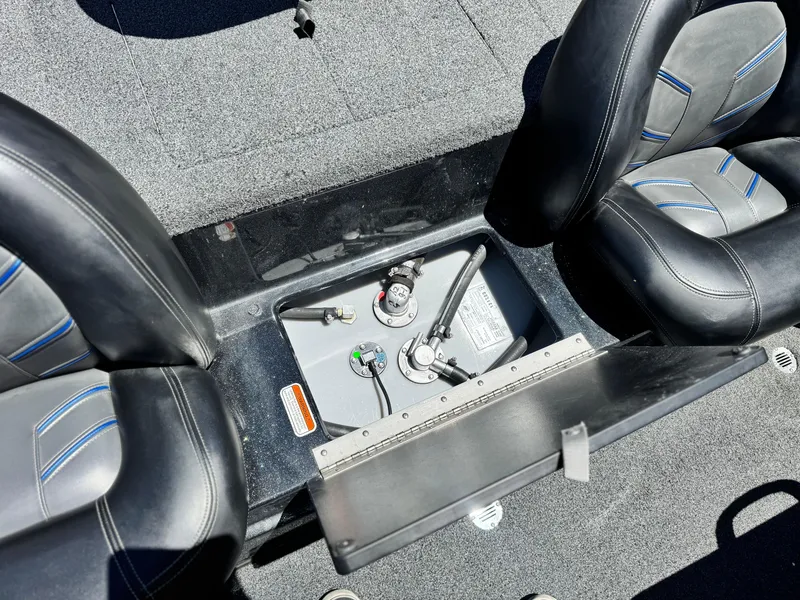Slide: The Image of 2024 Tracker Z17 boat interior with open storage compartment between seats. - 14