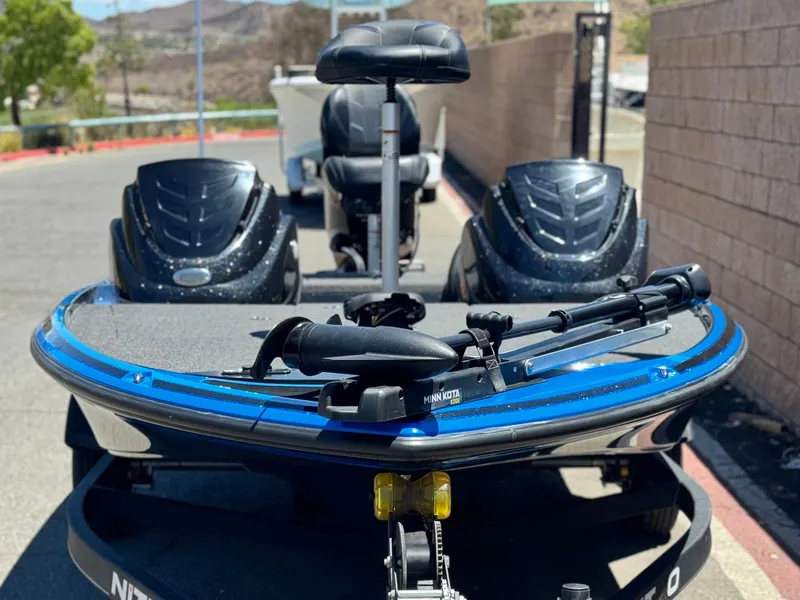 Slide: The Image of 2024 Tracker Z17 boat with Minn Kota trolling motor, parked outdoors. - 2