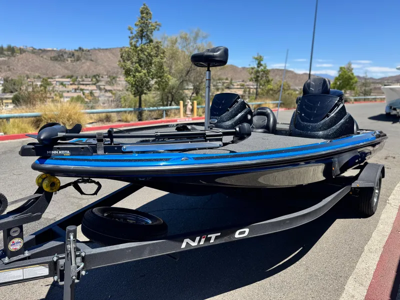 Slide: The Image of 2024 Tracker Z17 boat on trailer, featuring Minn Kota motor, parked outdoors. - 3