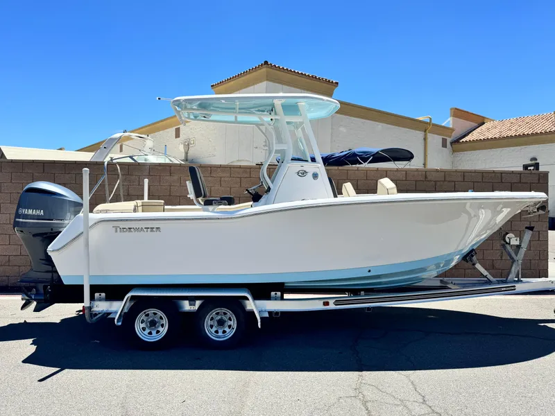 The Image of 2022 Tidewater 232 CC boat on trailer, parked outdoors under clear blue sky. - 0