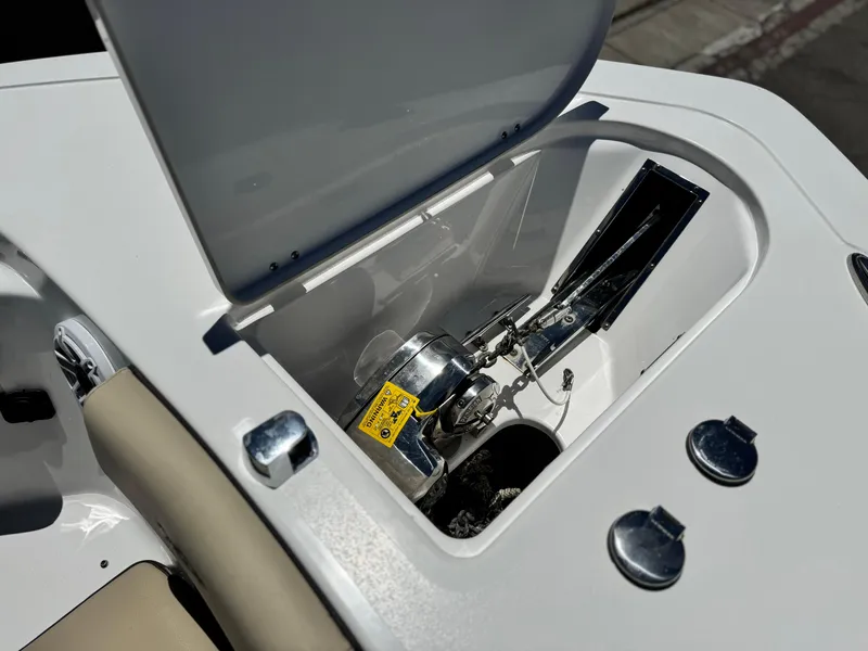 Slide: The Image of 2022 Tidewater 232 CC boat anchor compartment with open lid, showcasing anchor mechanism. - 10