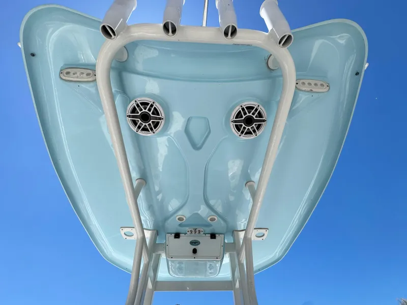 Slide: The Image of 2022 Tidewater 232 CC boat underside with speakers and rod holders against blue sky. - 15