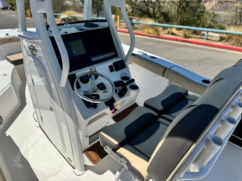 Slide: The Image of 2022 Tidewater 232 CC boat console with steering wheel and seating. - 24