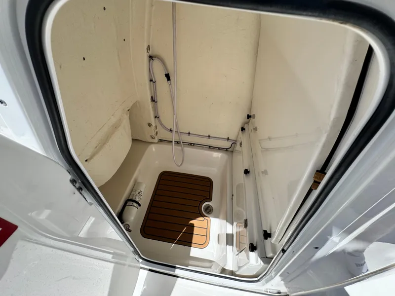 Slide: The Image of 2022 Tidewater 232 CC boat interior with shower and wooden floor panel. - 29