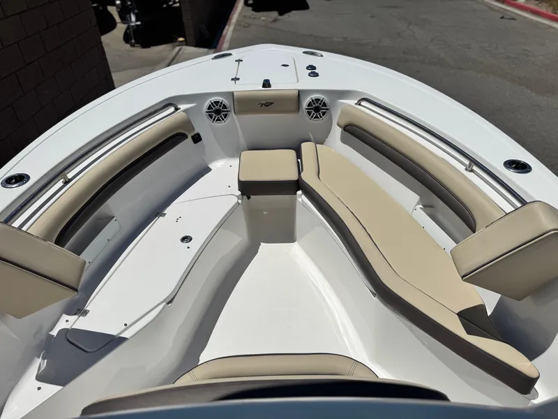 Slide: The Image of 2022 Tidewater 232 CC boat interior with beige seating and speakers. - 8