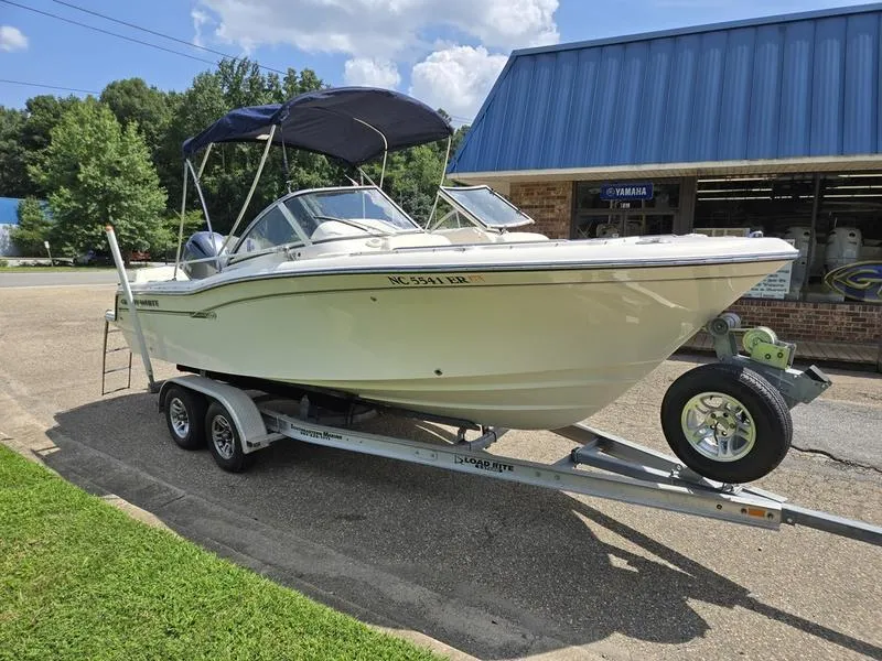 Slide: The Image of 2018 Grady-White Freedom 215 boat on trailer, parked outside a blue-roofed building. - 3
