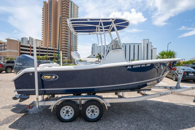 Slide: The Image of 2014 Sea Hunt 196 Ultra Center Console boat on trailer, parked in urban setting. - 4