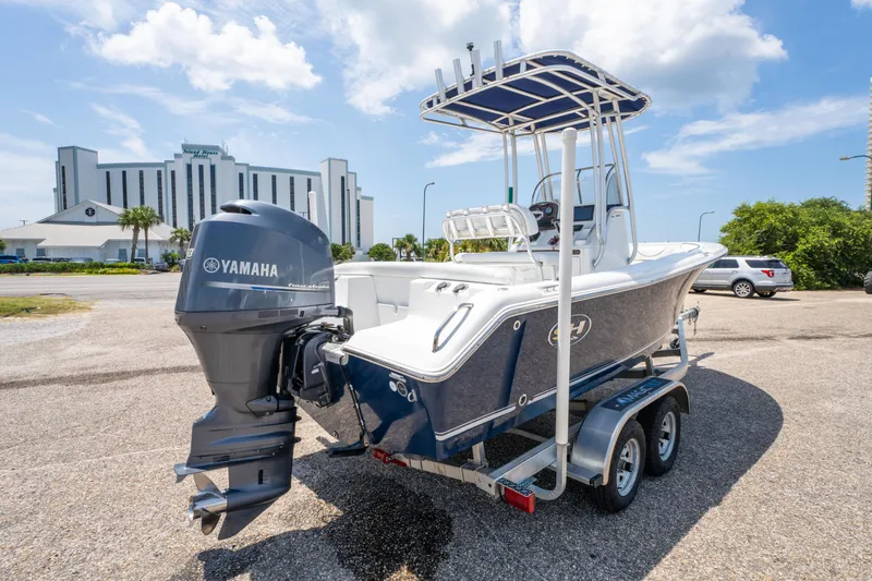 Slide: The Image of 2014 Sea Hunt 196 Ultra Center Console boat on trailer, with Yamaha engine, parked outdoors. - 6