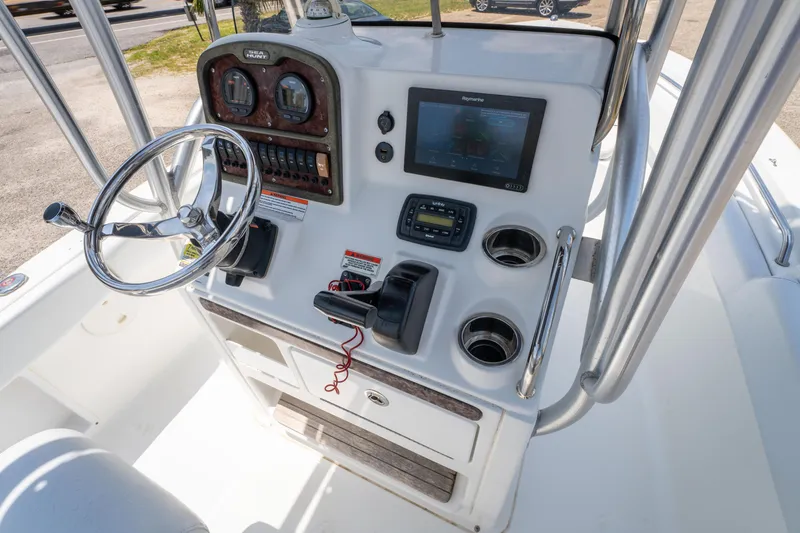 Slide: The Image of 2014 Sea Hunt 196 Ultra Center Console boat dashboard with steering wheel and navigation controls. - 9