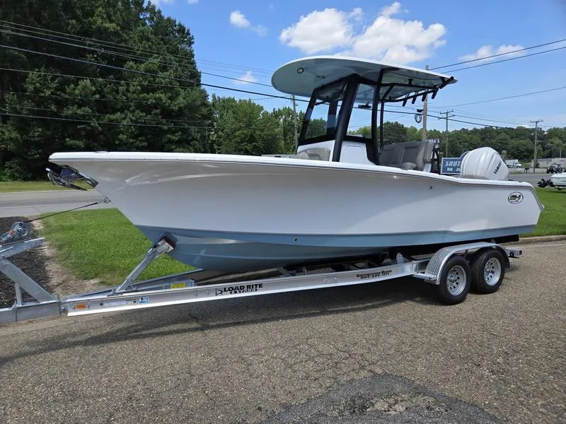 The Image of 2026 Sea Hunt Ultra 245SE boat on trailer, parked outdoors under blue sky. - 1