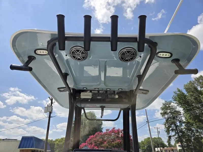 Slide: The Image of 2026 Sea Hunt Ultra 245SE boat top with rod holders and speakers under a blue sky. - 12