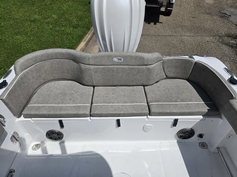 Slide: The Image of 2026 Sea Hunt Ultra 245SE boat seating area with gray cushions and white trim. - 15