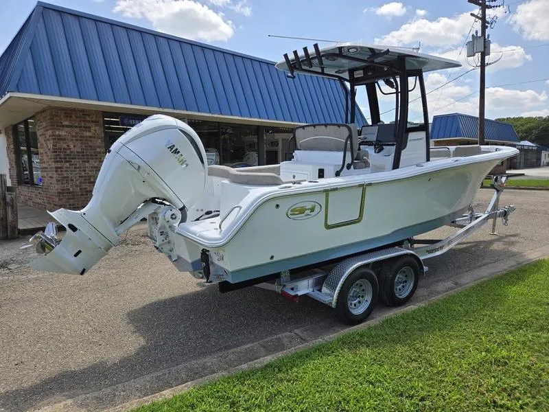 Slide: The Image of 2026 Sea Hunt Ultra 245SE boat on trailer, parked outside a building. - 9