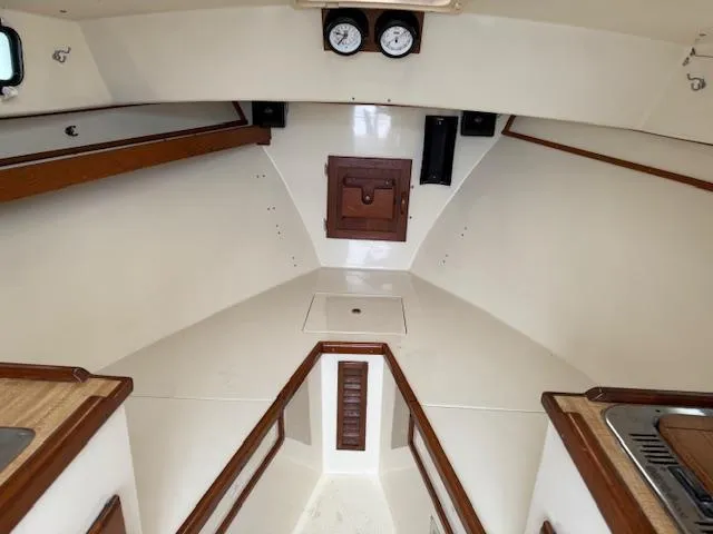 Slide: The Image of Interior of a 1993 Fortier 26 boat, featuring wood accents and gauges. - 10