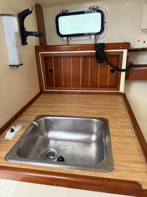 Slide: The Image of 1993 Fortier 26 boat interior with wooden countertop and stainless steel sink. - 13
