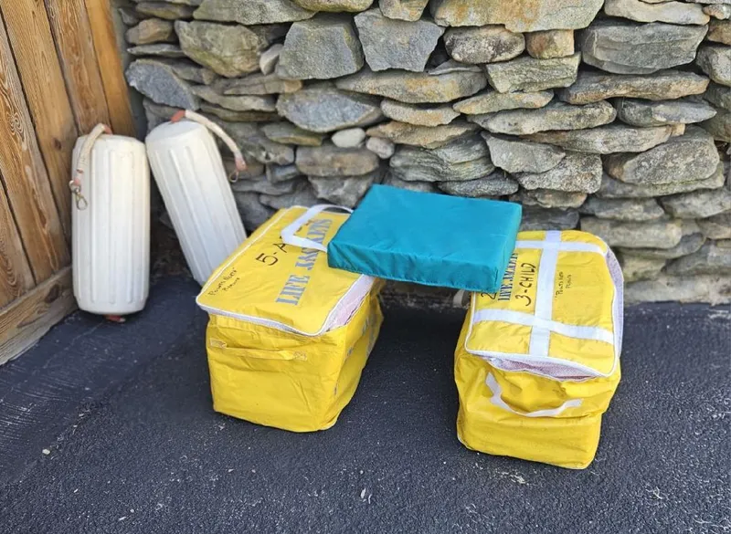 Slide: The Image of Yellow life jackets and boat fenders against a stone wall, Fortier 26, 1993. - 17