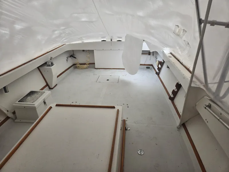 Slide: The Image of Interior of a 1993 Fortier 26 boat, featuring a spacious, covered deck area. - 6