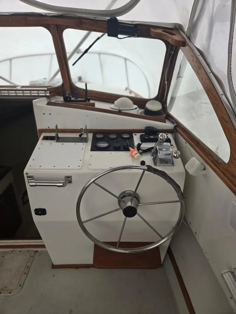 Slide: The Image of 1993 Fortier 26 boat helm with steering wheel and control panel. - 8