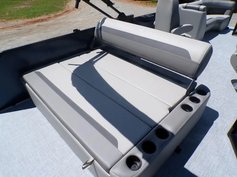 Slide: The Image of 2025 Premier 220 SUNSCAPE RL boat seating with cup holders, outdoor setting. - 14