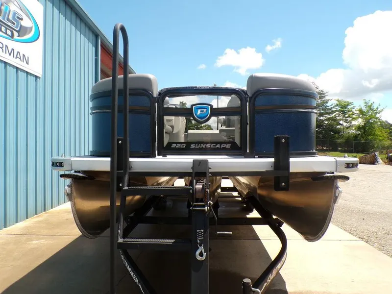 Slide: The Image of 2025 Premier 220 SUNSCAPE RL pontoon boat on trailer, outdoor display. - 2