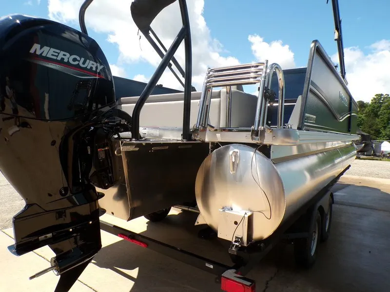 Slide: The Image of 2025 Premier 220 SUNSCAPE RL pontoon boat with Mercury outboard motor, parked on trailer. - 4