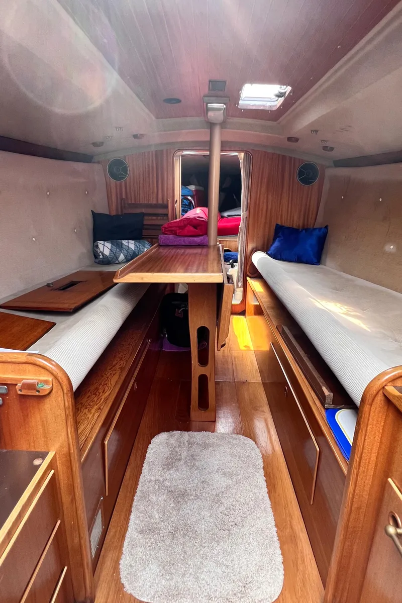 Slide: The Image of Interior of a 1978 Aphrodite 101 sailboat with wooden furnishings and cozy seating. - 12