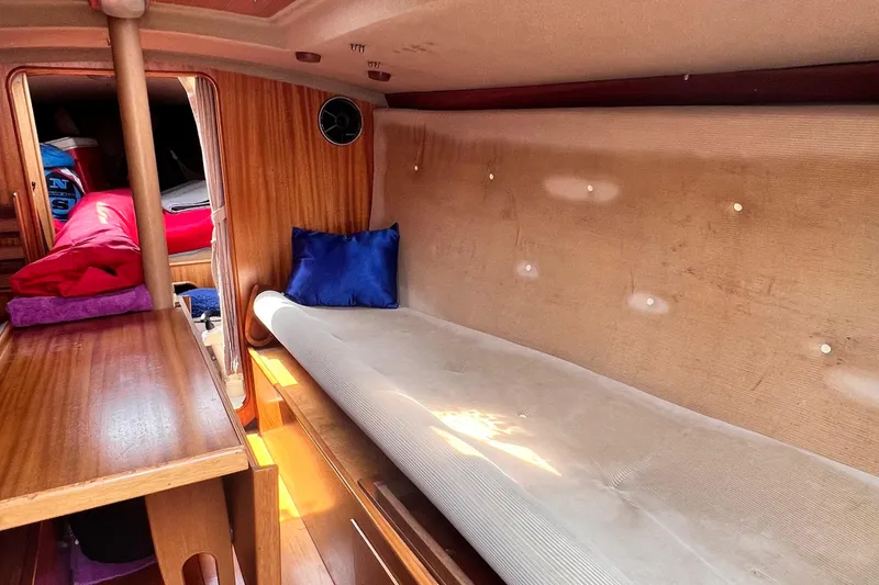 Slide: The Image of Interior of a 1978 Aphrodite 101 sailboat with wooden paneling and cushioned seating. - 13