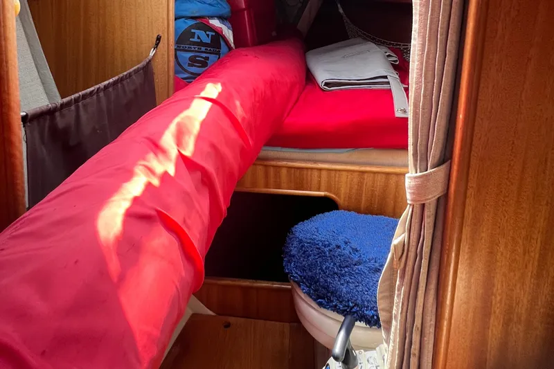 Slide: The Image of Interior of a 1978 Aphrodite 101 sailboat with red bedding and blue cushion. - 15