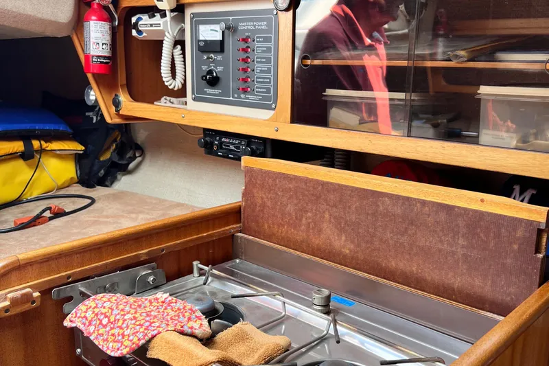 Slide: The Image of Interior of a 1978 Aphrodite 101 sailboat with stove and control panel. - 16