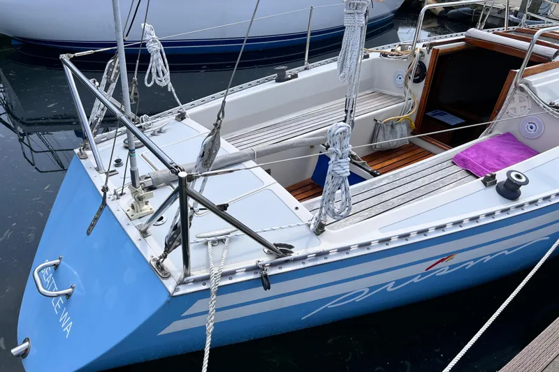 Slide: The Image of Aphrodite 101 sailboat from 1978 docked, featuring a blue hull and tidy deck. - 2