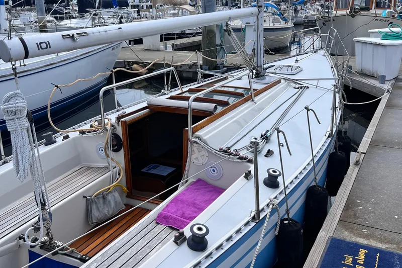 Slide: The Image of Aphrodite 101 sailboat from 1978 docked at a marina, featuring a sleek white design. - 3
