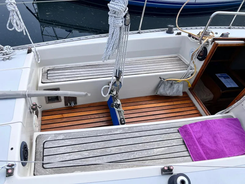 Slide: The Image of 1978 Aphrodite 101 sailboat cockpit with wooden flooring and purple towel. - 4