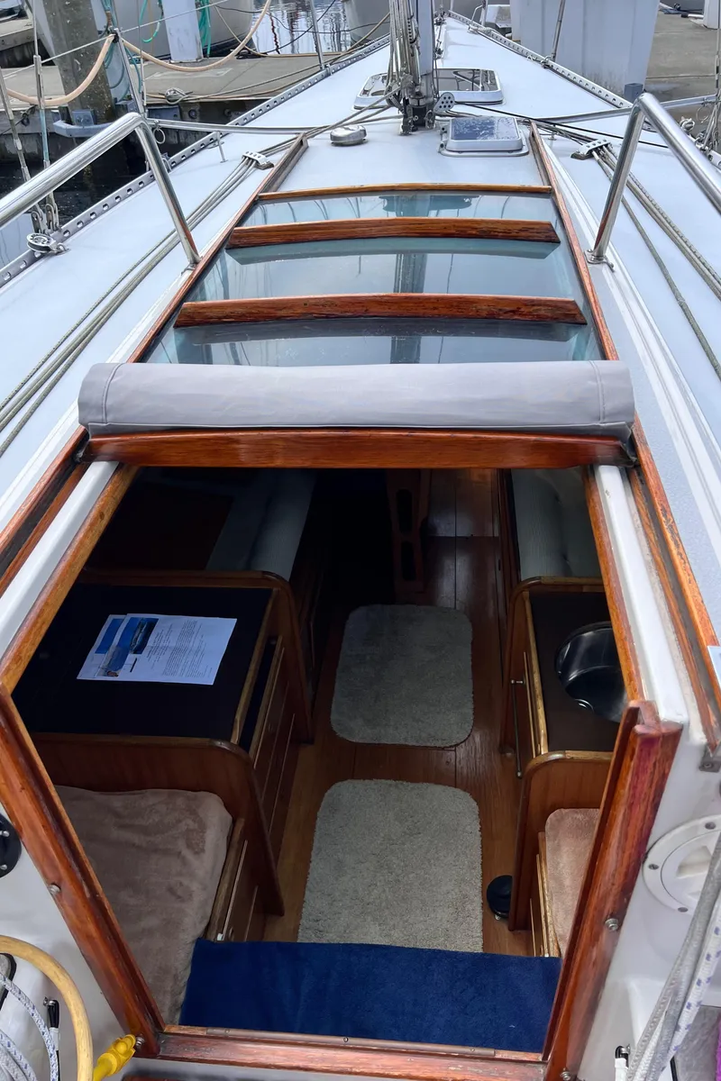 Slide: The Image of Interior view of 1978 Aphrodite 101 sailboat, showcasing wooden cabin and seating area. - 5