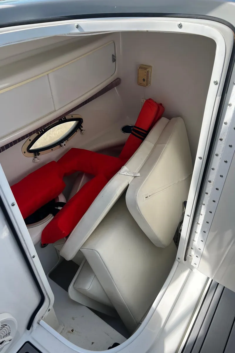 Slide: The Image of 2004 Formula 280 Bowrider cabin interior with red life jackets and white cushions. - 17