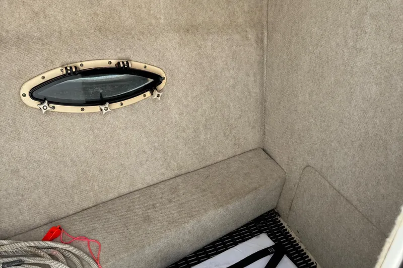 Slide: The Image of Interior of a 2004 Formula 280 Bowrider boat with a small window and carpeted walls. - 36
