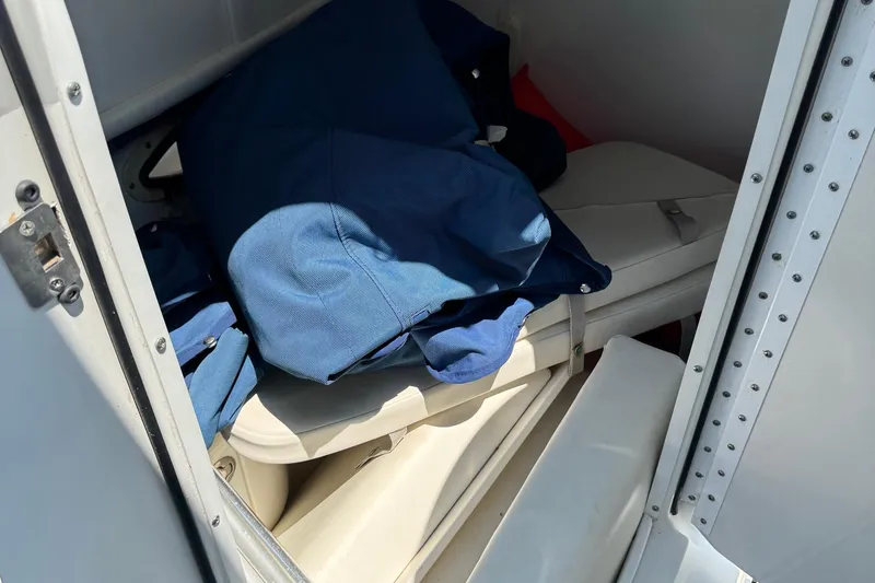 Slide: The Image of Storage compartment in a 2004 Formula 280 Bowrider boat with blue fabric items. - 37