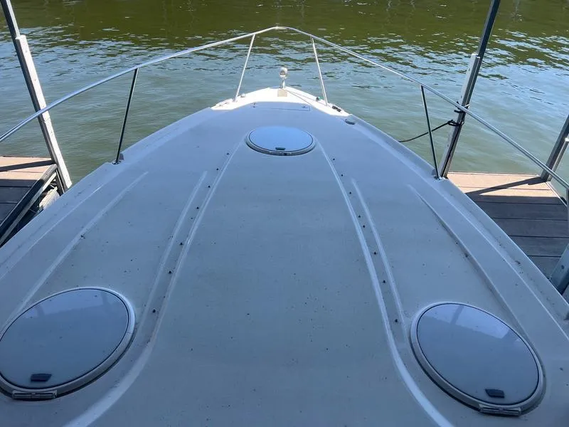 Slide: The Image of 2004 Four Winns 378 boat deck with hatches, docked on calm water. - 17