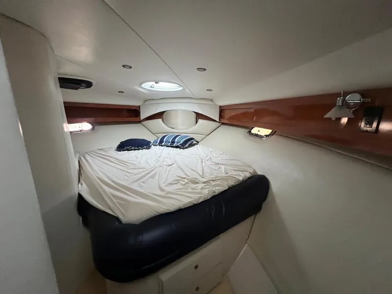 Slide: The Image of 2004 Four Winns 378 yacht cabin with bed, portholes, and wood accents. - 19
