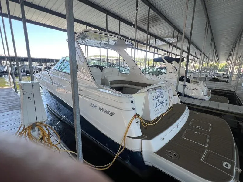 Slide: The Image of 2004 Four Winns 378 boat docked in a covered marina, rear view. - 4