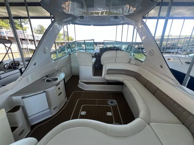 Slide: The Image of 2004 Four Winns 378 yacht interior with seating, sink, and helm under a covered dock. - 8