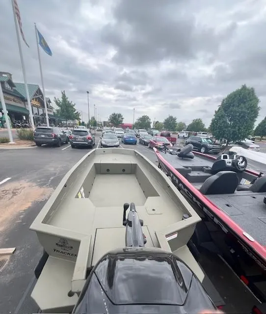 Slide: The Image of 2026 Tracker Grizzly 1650 T Prairie Wings Edition boat in a parking lot under cloudy skies. - 2