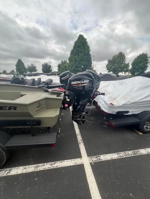 Slide: The Image of 2026 Tracker Grizzly 1650 T Prairie Wings Edition boat with Mercury outboard motor in parking lot. - 3