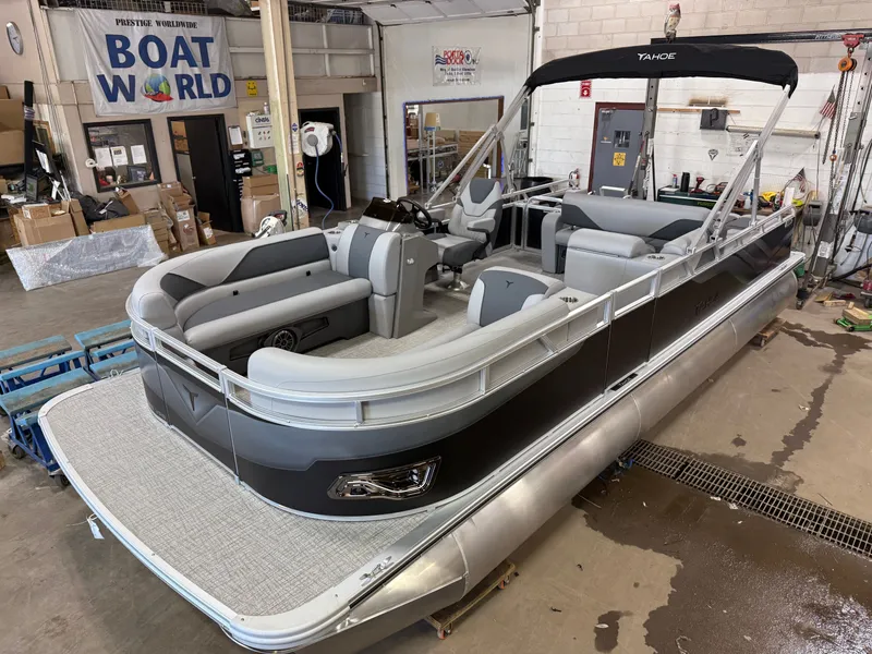 Slide: The Image of 2025 Tahoe Sport 2385 Swingback pontoon boat in showroom, featuring Honda 4-Stroke EFI engine. - 1