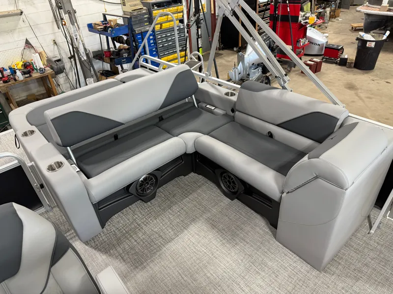 Slide: The Image of 2025 Tahoe Sport 2385 Swingback interior with gray seating and modern design in a workshop setting. - 16